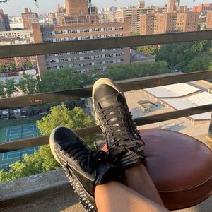 Studded black leather sneaker. Zipper detail.